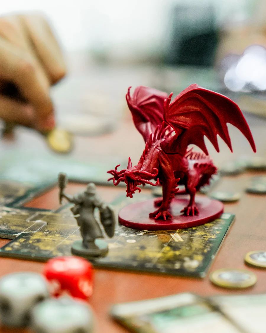 Miniatura de dragão vermelho posicionada sobre um mapa de RPG ao lado de dados